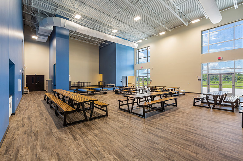 Inside of a school cafeteria with tables. 